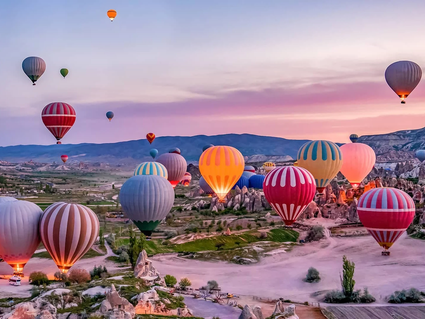 Hot air balloons flying over Cappadocia at sunrise